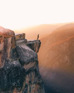 Man standing at edge of massive cliff