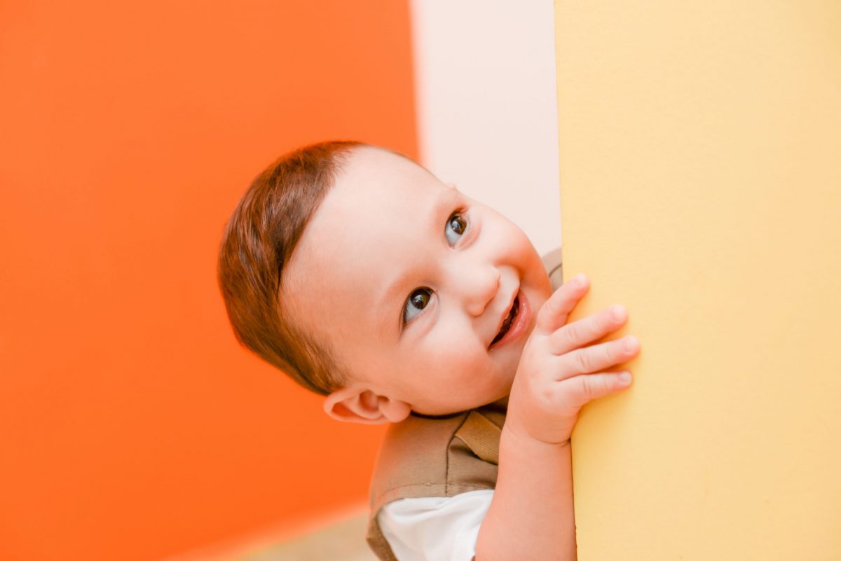 Smiling toddler peeking around corner