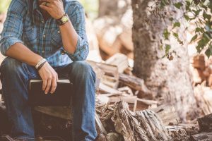 Man thinking or praying while holding Bible