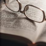 Glasses sitting on open Bible