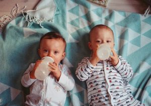 Two babies drinking milk from bottles